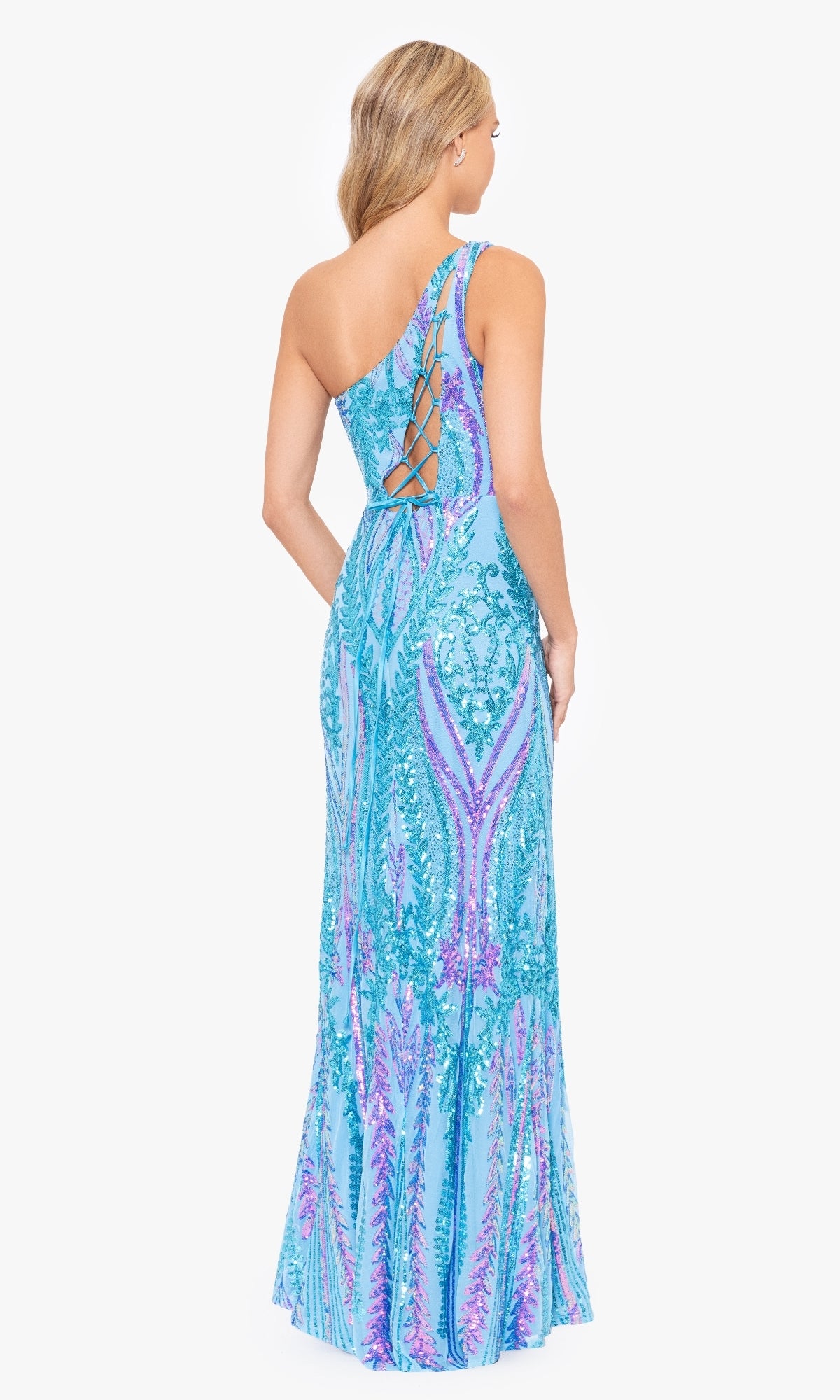 A woman wearing the Blondie Nites 4610BN long sequin-print prom dress stands facing away from the camera, showcasing its blue and purple one-shoulder design with lace-up back detailing.